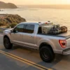 Modified pickup truck with camping gear driving on highway showing proper payload capacity management and level stance.